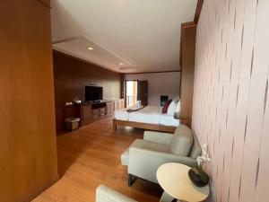 a living room with a couch and a bed in a room at The Canal Ratchaburi in Ratchaburi