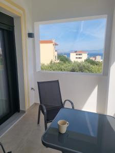 a table and a chair in a room with a window at Irides Apartments in Megalochori