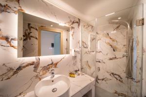 ein Badezimmer mit Waschbecken und Spiegel in der Unterkunft Creta Mare Hotel in Plakias
