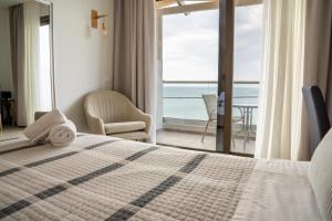 ein Schlafzimmer mit Bett und Meerblick in der Unterkunft Creta Mare Hotel in Plakias + 110 Fotos