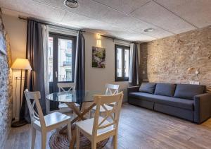 a living room with a couch and a table and chairs at Aromatik apartments in Girona