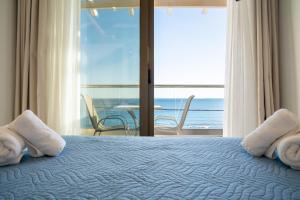 ein Schlafzimmer mit einem Bett und Meerblick in der Unterkunft Creta Mare Hotel in Plakias