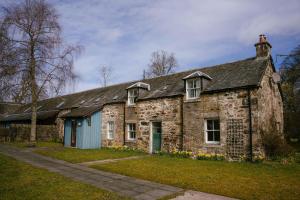 an old stone house with a blue door at Kindrogan House in Straloch