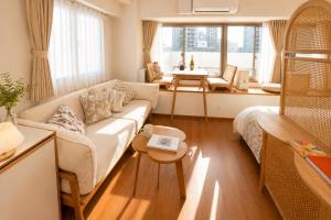 a living room with a couch and a table at Landmark Sunshine Hotel in Osaka