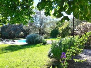 a garden with two chairs and a swimming pool at L'Escale Provençale in Tourrettes