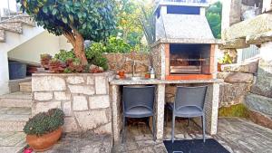 a outdoor kitchen with two chairs and a sink at Casa da Laija - Vistas rio - "Gerês" in Geres