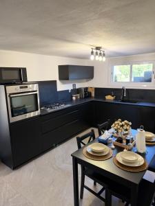 a kitchen with a table and a stove at Lumière du paradis in Villes-sur-Auzon