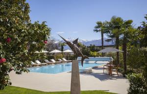 a statue of a bird standing next to a swimming pool at Appartamento Centovalli e Verzasca in Minusio