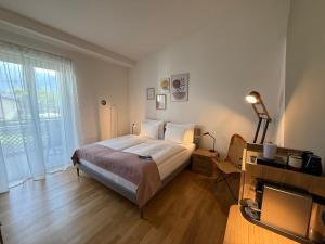 a bedroom with a bed and a large window at Appartamento Centovalli e Verzasca in Minusio +6 photos