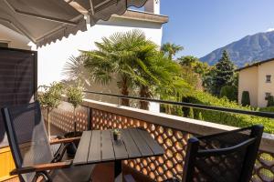 a table and chairs on a balcony with a view at Appartamento Centovalli e Verzasca in Minusio