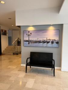 a large painting hanging on a wall with a bench at Venice Hotel con Colonnine Elettriche in Grisignano di Zocco