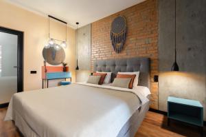 a bedroom with a large bed and a brick wall at 3-217 Rybalsky, Naberezhno Rybalska 3, Kyiv centre, panoramic city view, 15 kW backup power, Petrovdom Apartment in Kyiv