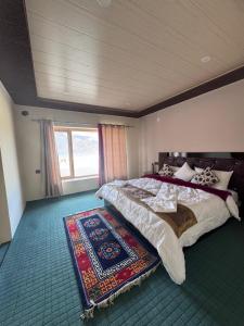 a bedroom with a large bed and a rug at Ostal Residency Pangong in Meruk