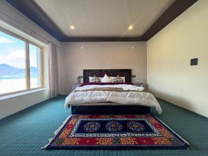 a bedroom with a bed with a rug on the floor at Ostal Residency Pangong in Meruk +8 photos