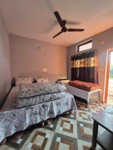 ein Schlafzimmer mit zwei Betten und einem Deckenventilator in der Unterkunft Devom Guest House in Phata