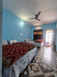 ein Schlafzimmer mit zwei Betten und einem Deckenventilator in der Unterkunft Devom Guest House in Phata