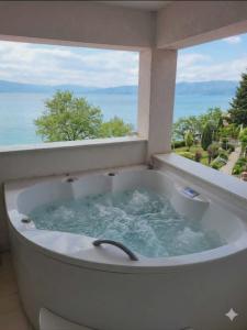 a bath tub with a view of the ocean at Nikita Lux in Lagadin +1 photo