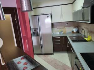 a kitchen with white cabinets and a stainless steel refrigerator at Nikita Lux in Lagadin