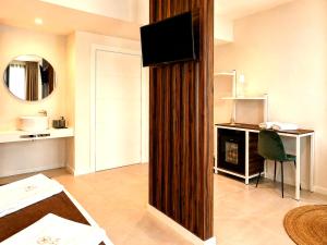 a hotel room with a bed and a television on a wall at Hotel Kavia Sarria in Sarria