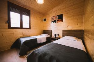 a bedroom with two beds in a wooden cabin at Casa Arte 2 in Ulcinj
