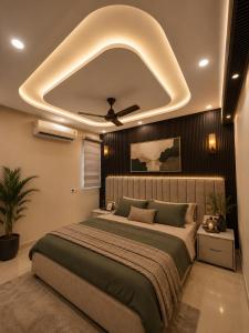 a bedroom with a large bed with a ceiling at Dream Residency in Karnal