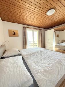 a bedroom with two beds with a wooden ceiling at Haus Bünten in Quinten