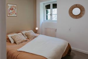 a bedroom with a bed and a mirror on the wall at Villa de Meslay in Montaigu-Vendée