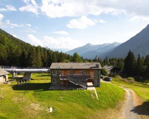a small building on a hill with mountains in the background at Baita sulle piste in Valmalenco in Chiesa in Valmalenco