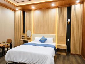 a bedroom with a bed with a blue pillow on it at Panda Hotel in Long Thành
