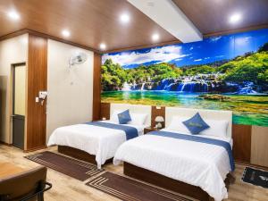 two beds in a room with a waterfall mural at Panda Hotel in Long Thành +18 photos