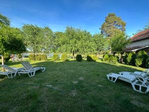 two picnic tables and chairs in a yard at Vila Plaza-1 in Bela Crkva