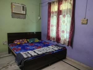 a small bed in a room with a window at Jp Homestay in Vrindāvan
