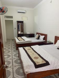 a room with three beds and a mirror at Khách sạn Thuỷ Chi in Bắc Quang