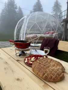 a picnic table with a pie and glasses of wine at Panorama-Bubble Klewenalp in Beckenried