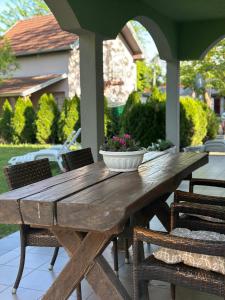 a wooden table with a bowl of flowers on a patio at Vila Plaza-1 in Bela Crkva