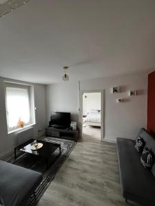 a living room with a couch and a table at Appartement au 1 er étage côté jardin in Thaon-les-Vosges