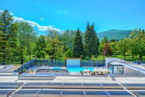 a swimming pool with a fence and mountains in the background at Hotel Alkar - Family Friendly Hotel with Pool in Sinj, Dalmatia in Sinj