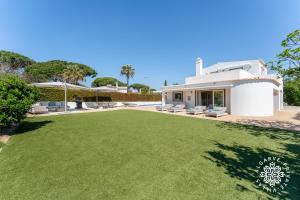 a large lawn in front of a house at Villa Benjamin - Vale do Lobo in Vale do Lobo