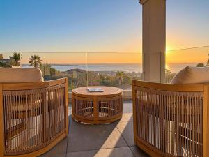 a balcony with a view of the ocean and a table at Sea View Villa Roc d'Azur - Pool - Jacuzzi in Vallauris +55 photos