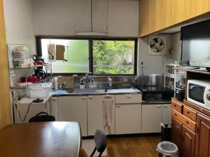 eine kleine Küche mit Spüle und Fenster in der Unterkunft Nabiki in Hongu + 18 Fotos