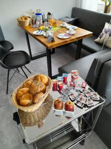 a table with a basket of bread and fruit on it at Pension Merkle in Ichenhausen +6 photos