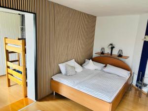 a bedroom with a bed with a striped wall at Pension Merkle in Ichenhausen