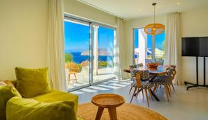 a living room with a couch and a table with a view at Luxury Villa with Panoramic Sea Views in Thólos