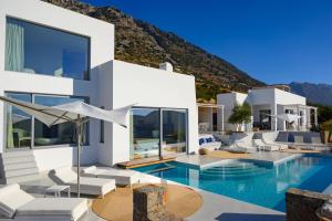a villa with a swimming pool with mountains in the background at Luxury Villa with Panoramic Sea Views in Thólos