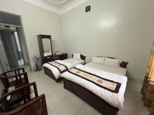 a bedroom with two beds and a mirror at Khách sạn Thuỷ Chi in Bắc Quang