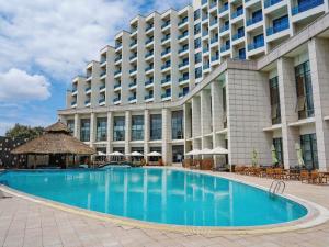 a hotel with a large swimming pool in front of a building at Ethiopian Skylight Hotel in Addis Ababa