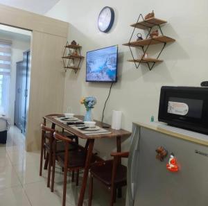 a dining room with a table and a refrigerator at Condo unit open for staycation in Manila