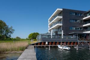 a building with a dock and a boat on the water at Veerse Muze in Kamperland