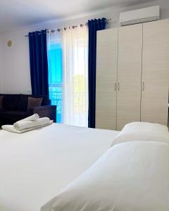 a bedroom with a white bed and a window at Residence Kullat in Velipojë
