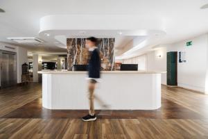 a person standing at a counter in an office at Hotel Miami Calella in Calella +50 photos